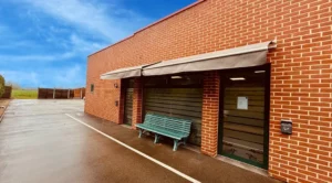 Façade en briques d'une chambre funéraire avec banc et store.
