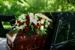 Corbillard ouvert transportant un cercueil recouvert de fleurs.